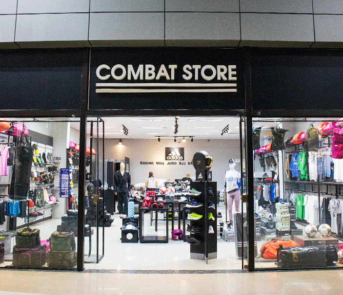 A frente da Loja Combat Store no Shopping del Este, mostrando uma vitrine com vários produtos de esporte